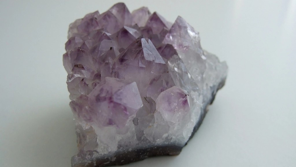Natural amethyst crystal cluster with purple quartz points in daylight
