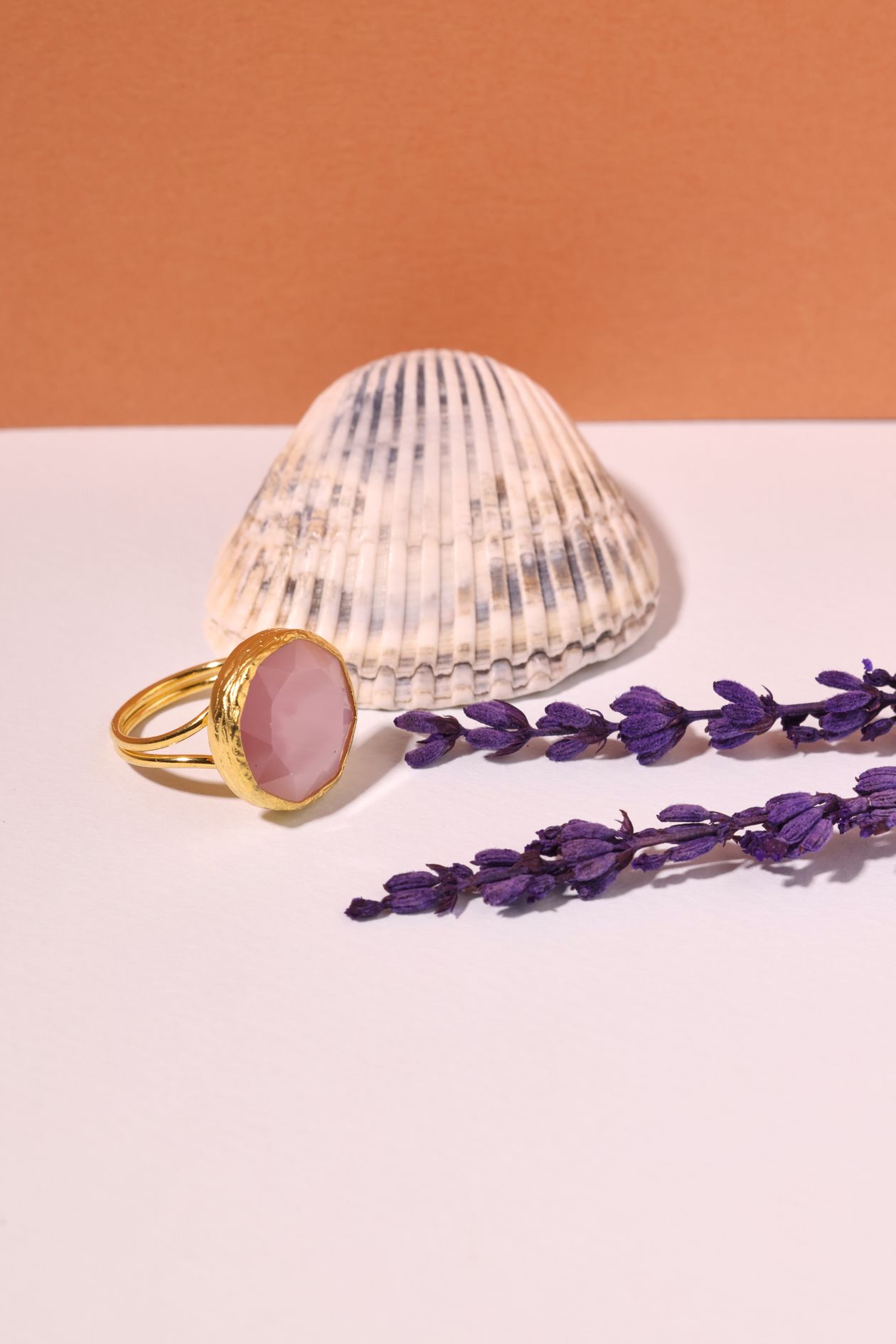 Rose quartz engagement ring with a pale-pink faceted stone in a gold bezel setting